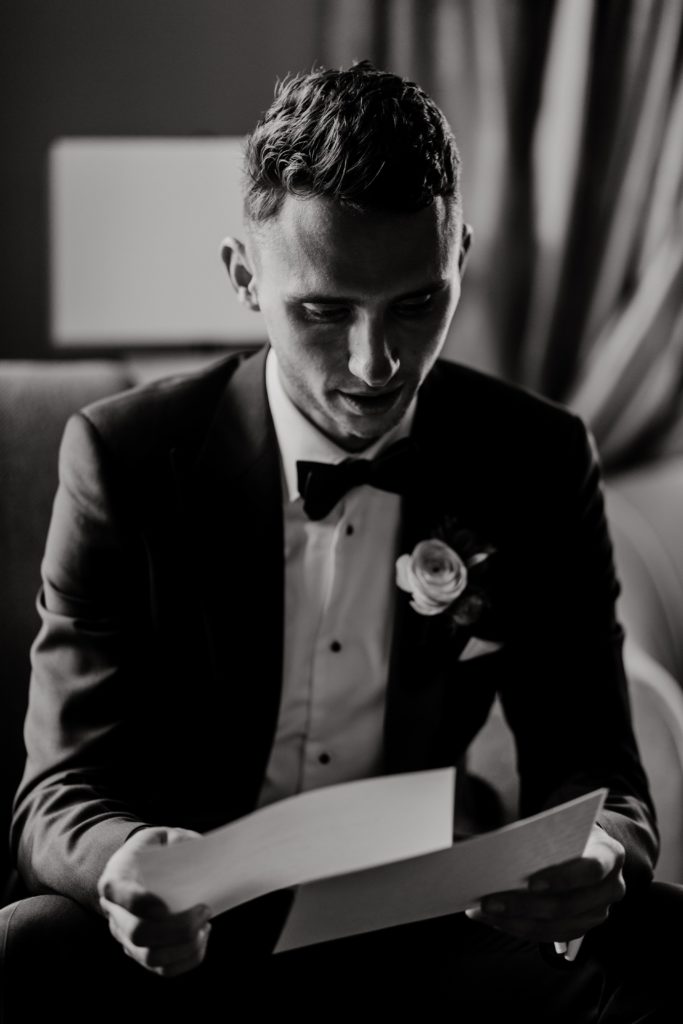 Groom reading letter from his bride before wedding