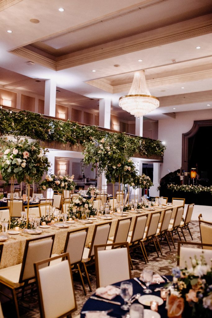 Luxury ballroom décor (white dance floor, hemstitch napkins, floating greenery trellis)