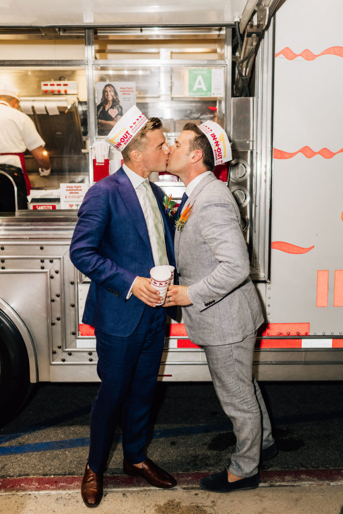 Grooms kissing in front of the In-N-Out truck at their Dana Point wedding