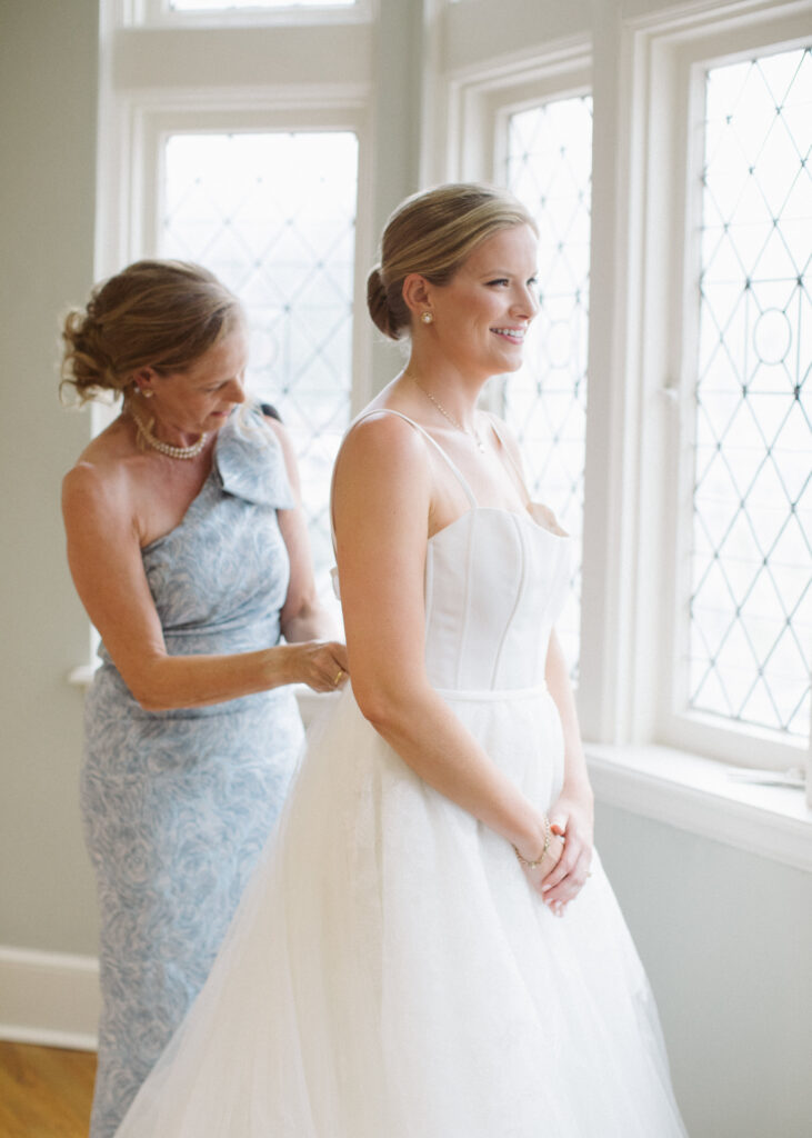 Bride and her mom get ready for the wedding after planning together
